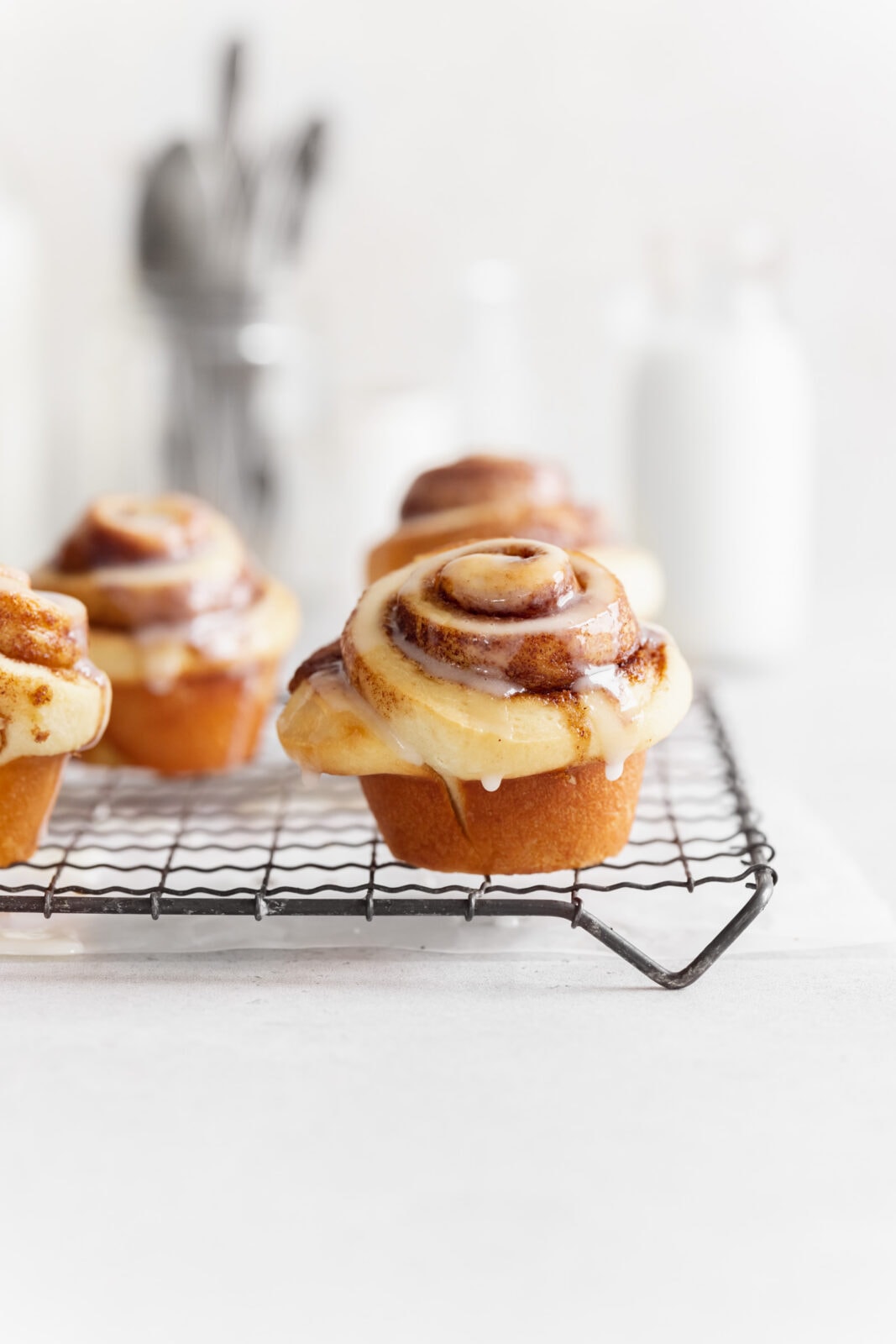  cinnamon roll muffins on cooling rack