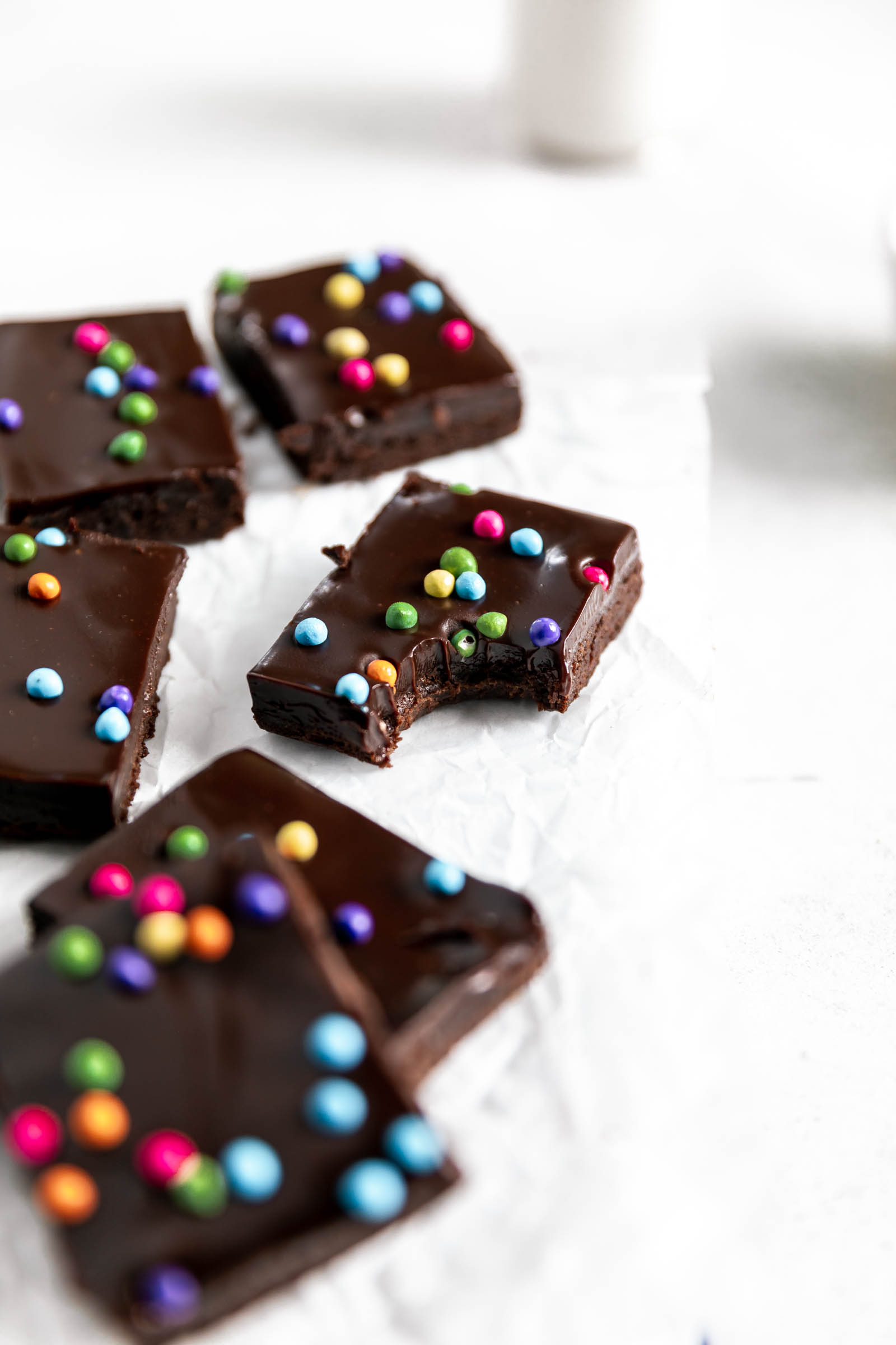 fudgy brownies with candy chocolate sprinkles and a bite taken out of it